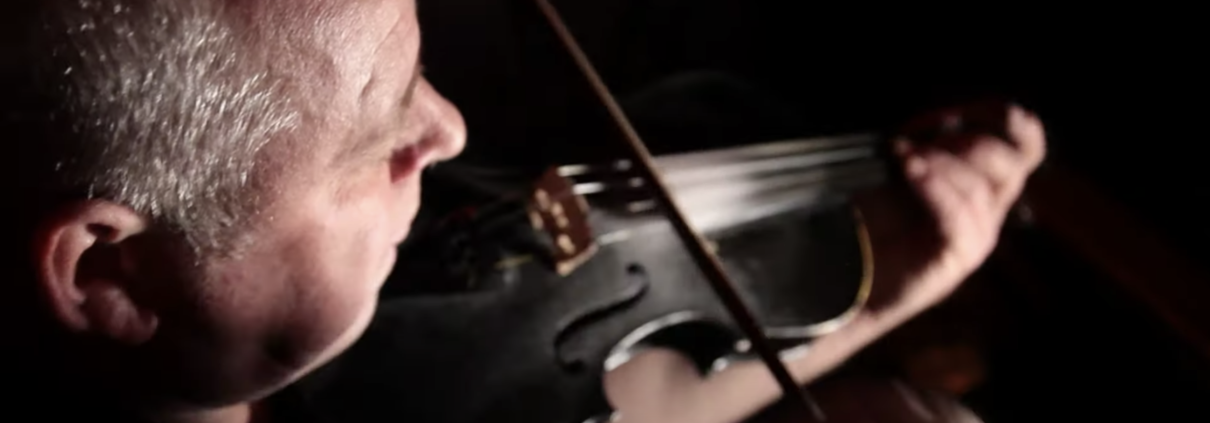 man playing fiddle for Destination Derry St Pats Eve Event